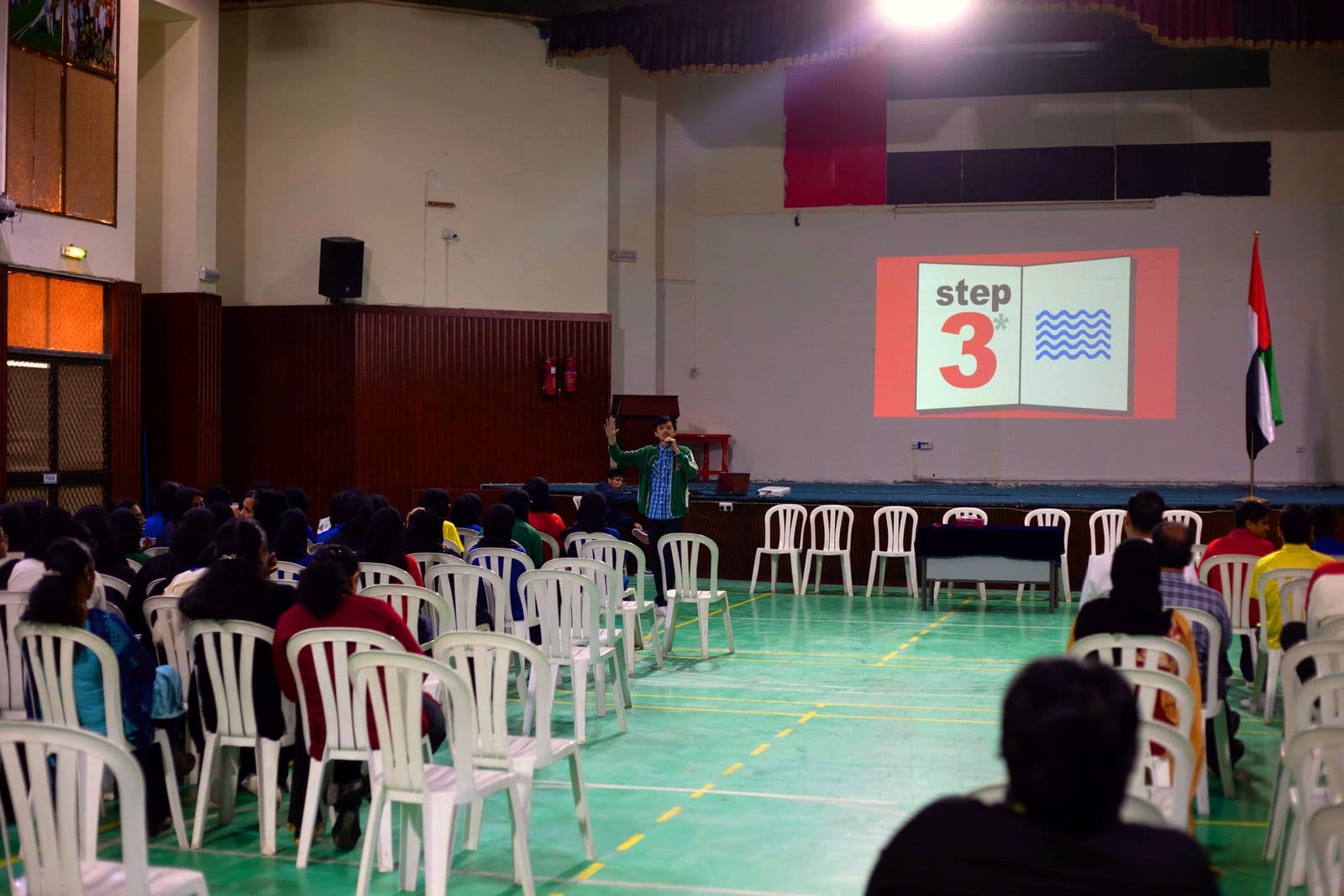 An audience listening to a speaker in the auditorium