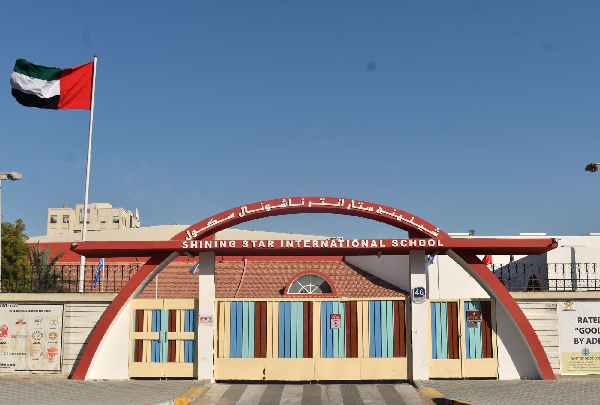 The school's arched main gate in Shabiya 12, Musaffah, under the UAE flag