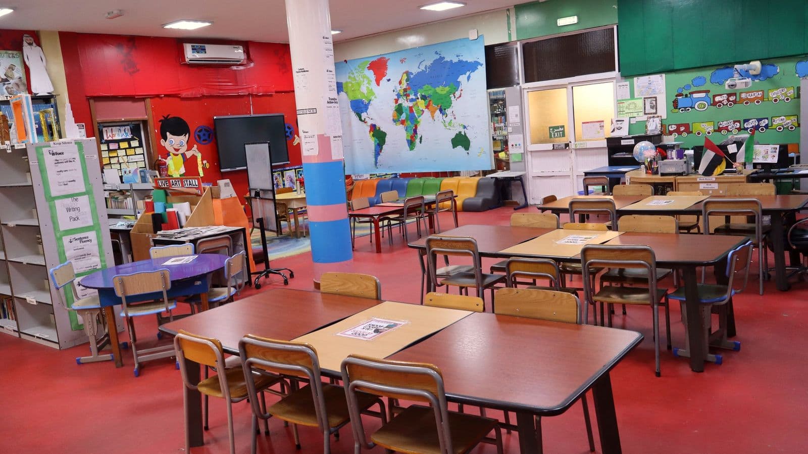 The junior library with a world map mural and reading tables