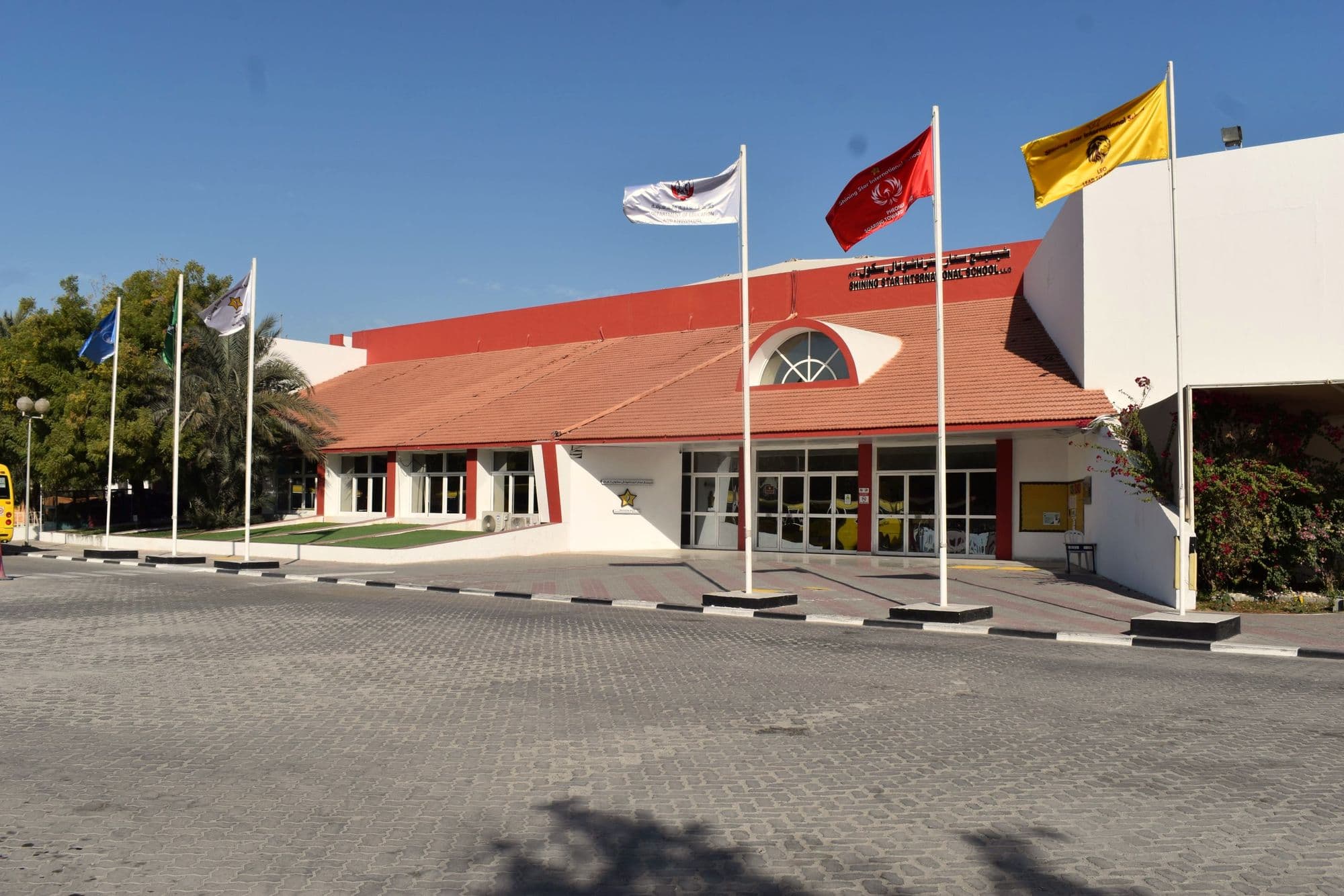 The main school building and its flags, seen from the forecourt