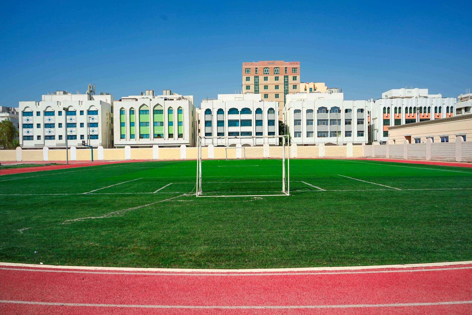 Football goals on the astro-turf field under a clear sky