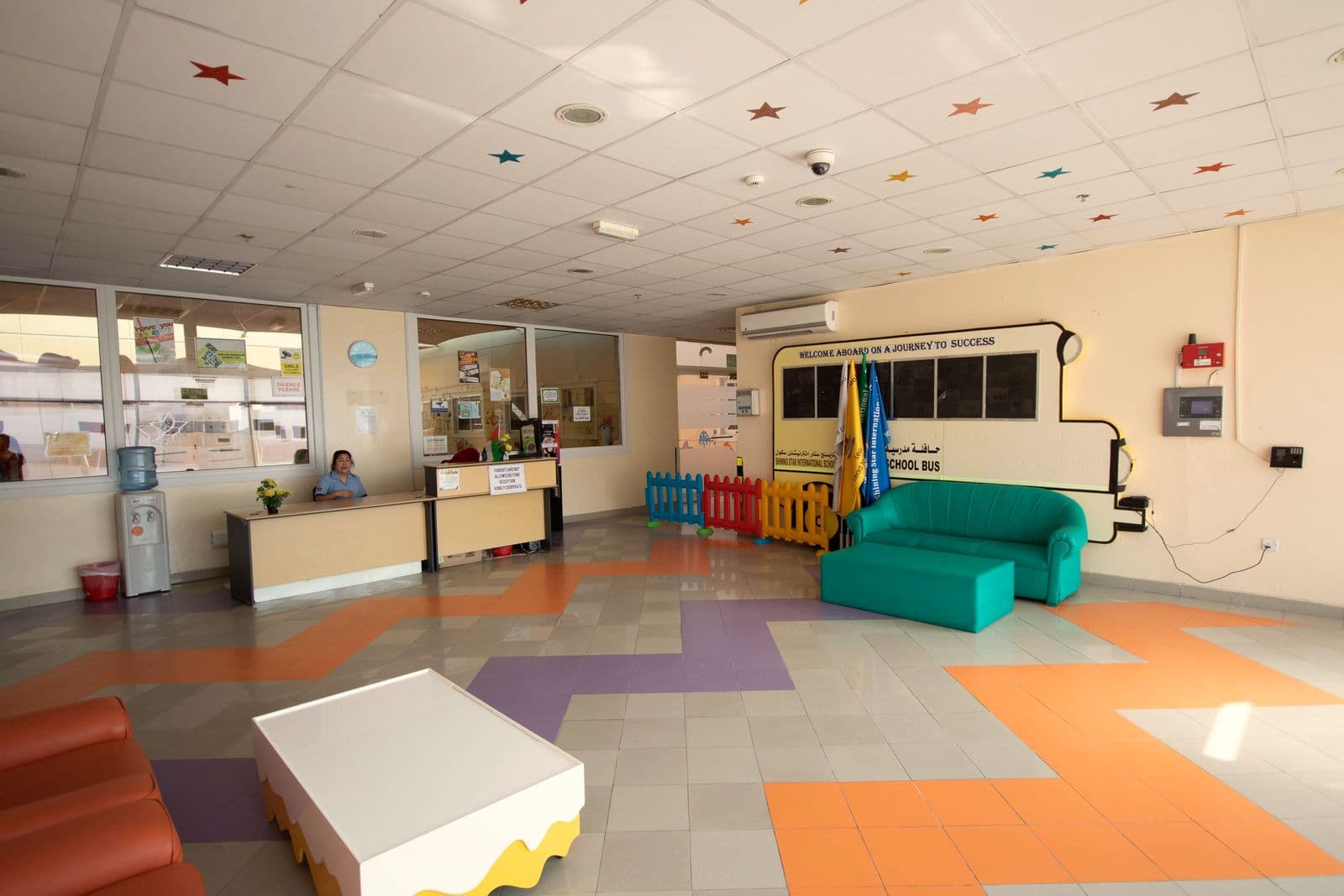 The bright entrance hall with colourful zig-zag flooring and soft seating