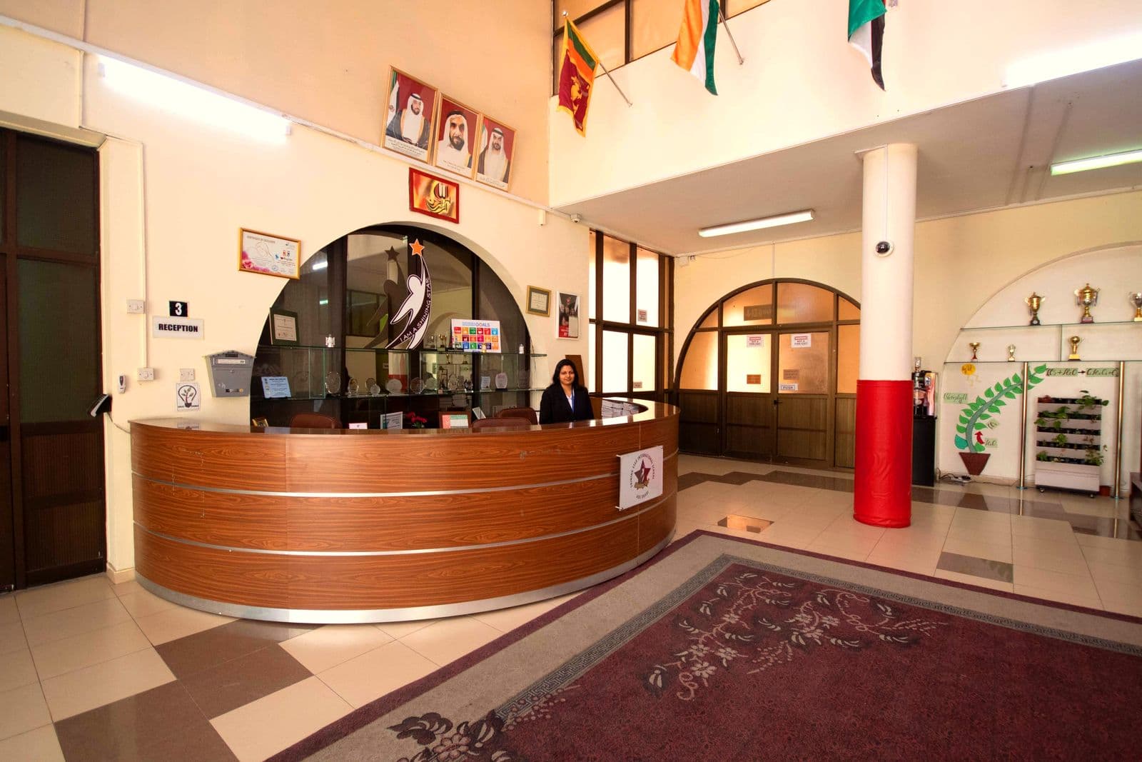 The school reception desk with the UAE leaders' portraits above it