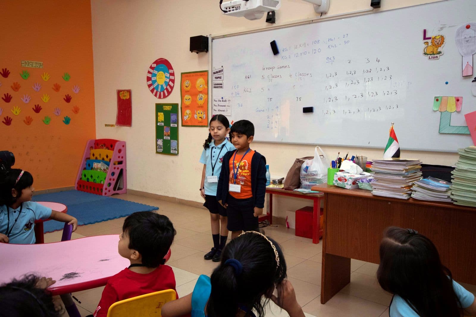 Two young pupils presenting at the front of their classroom