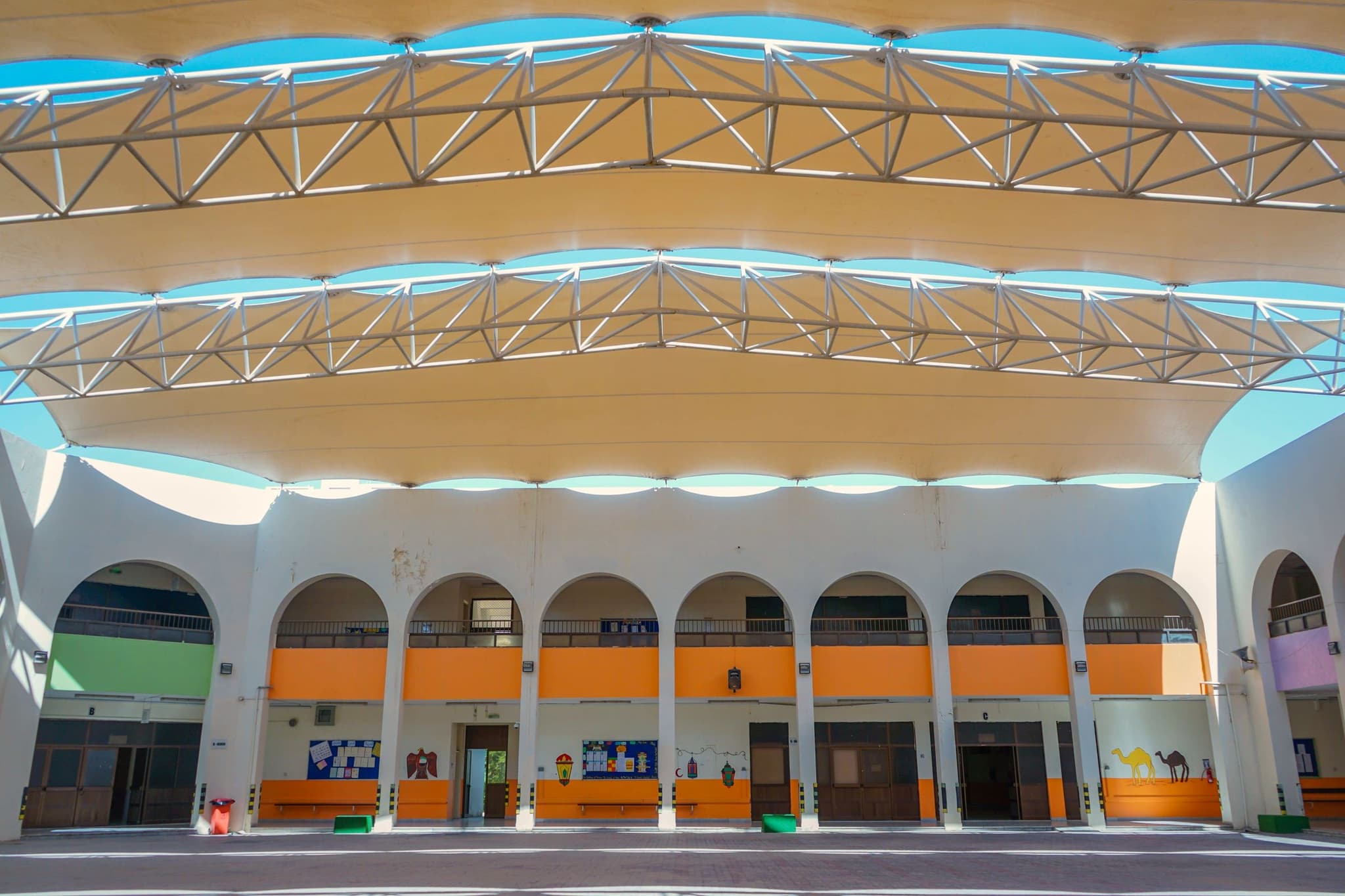 The covered central courtyard with two floors of arched classroom corridors