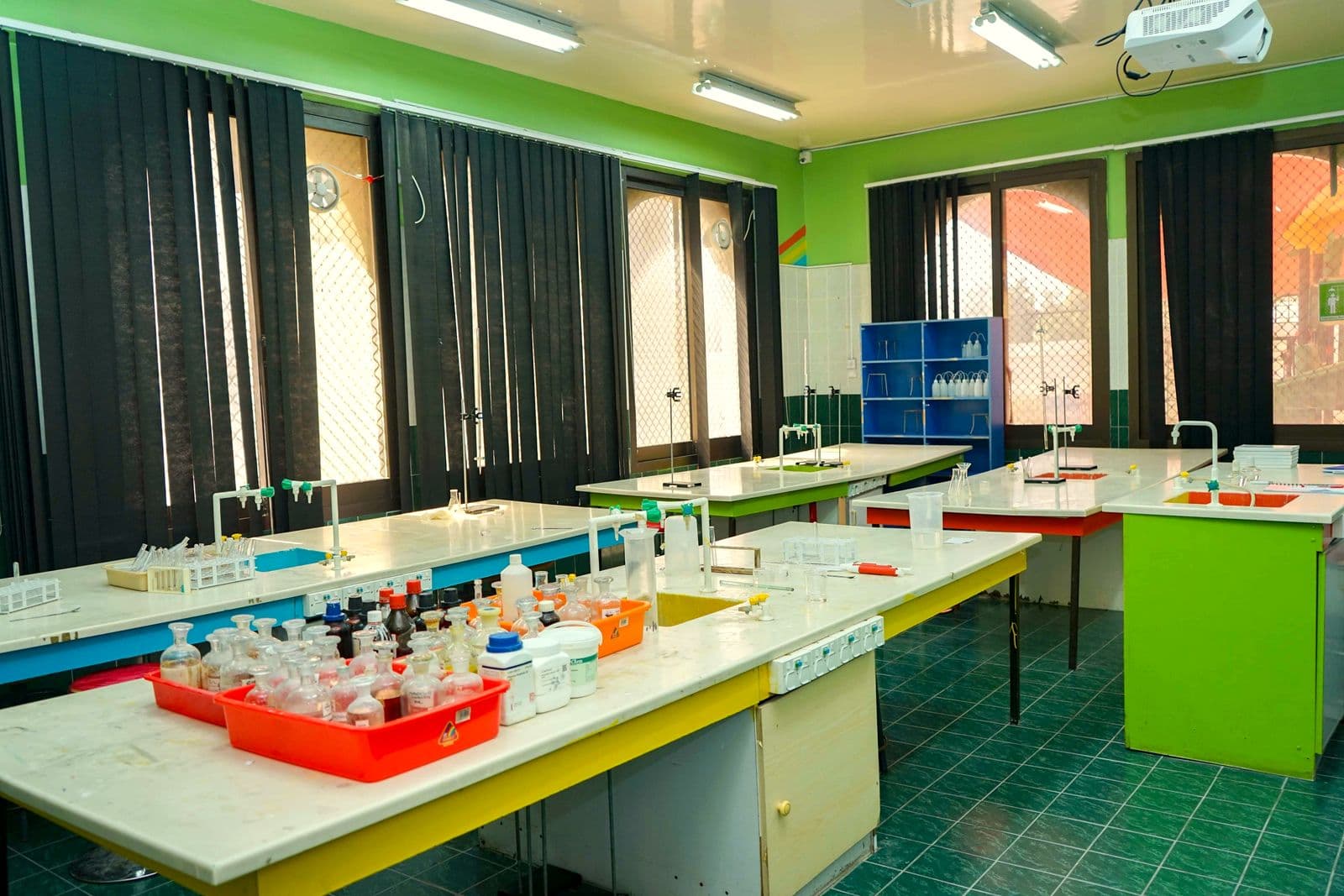 The science lab with colour-coded workbenches and trays of equipment